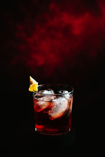 Close-up of negroni cocktail drink against black background