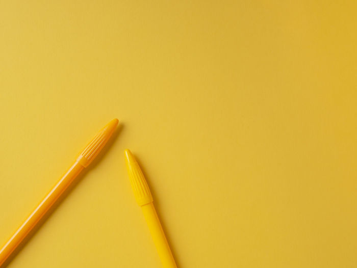 High angle view of pencils against yellow background