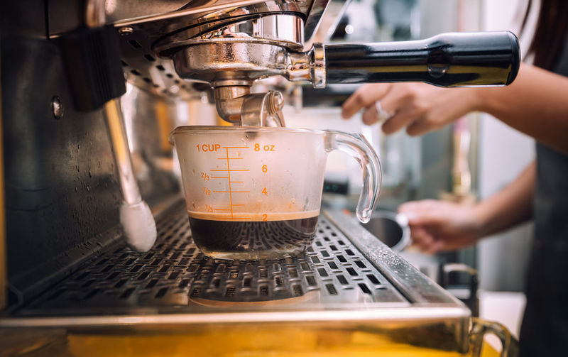 Cropped image of pouring coffee in cafe