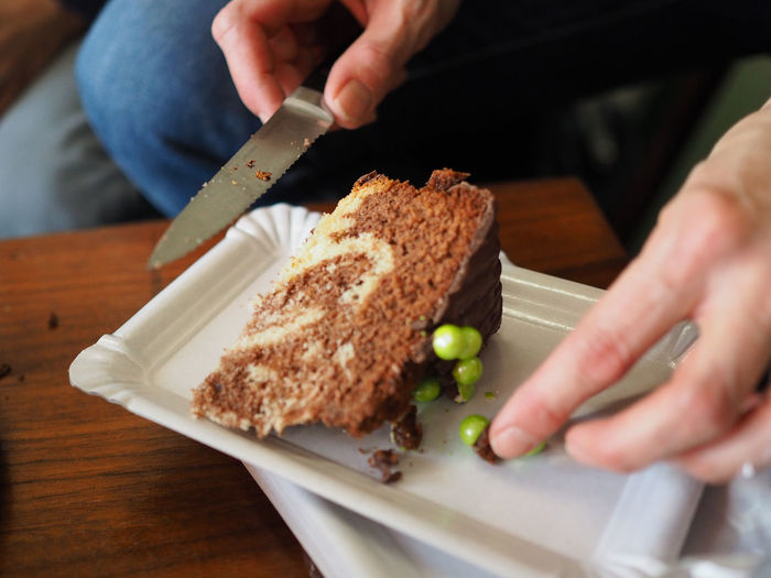 Close-up of man holding knife and cake