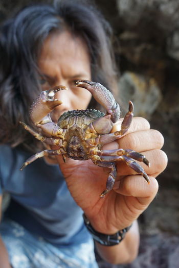 Close-up portrait of woman showing crab