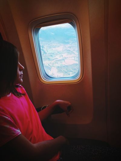 Rear view of woman sitting in plane