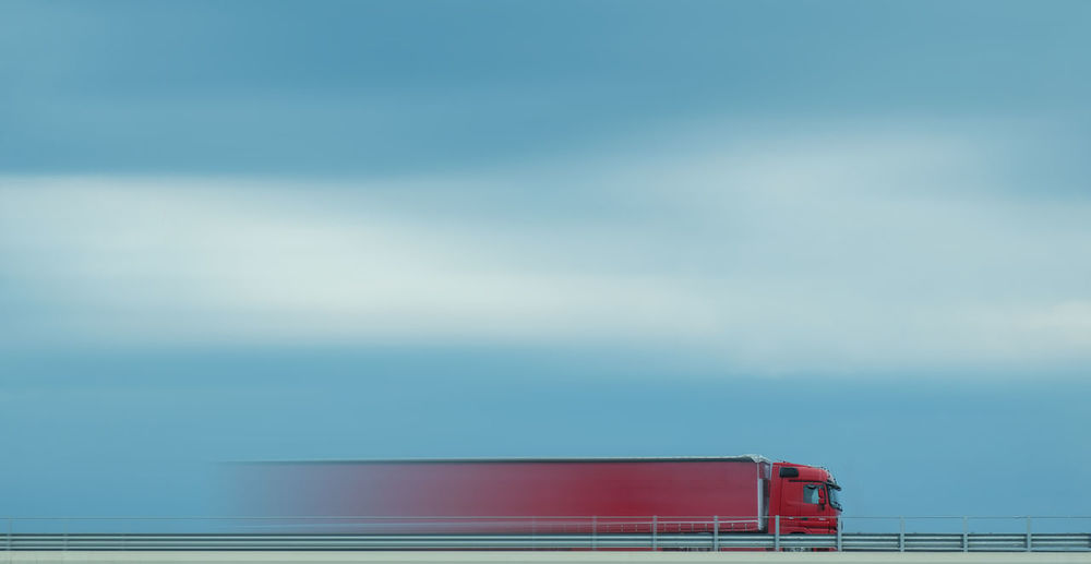 View of fast moving red truck on the road