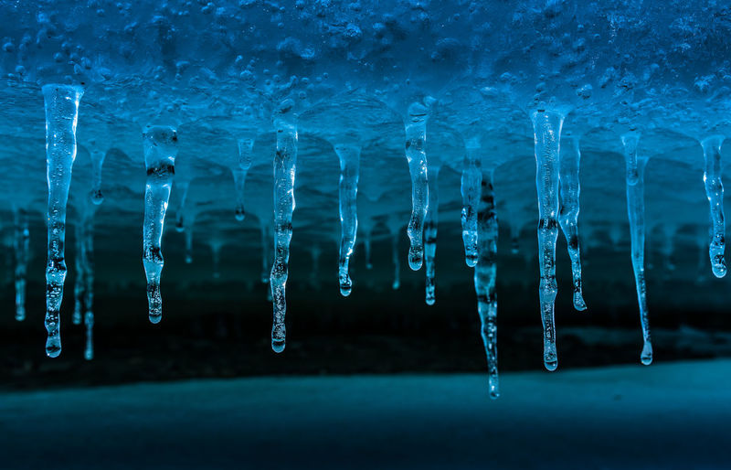 Close-up of icicles against blue sky