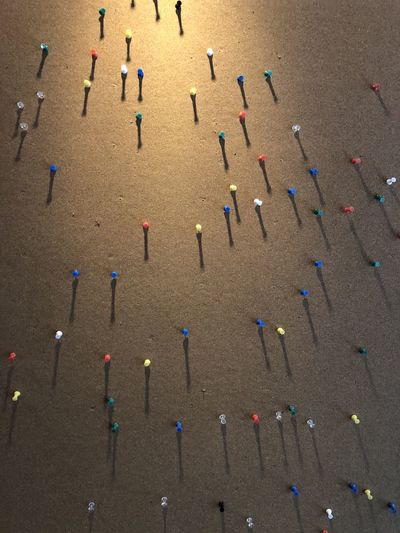 High angle view of multi colored pushpins in row