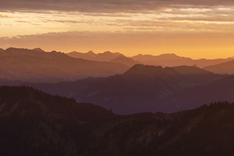 Scenic view of silhouette mountains against sky during sunset