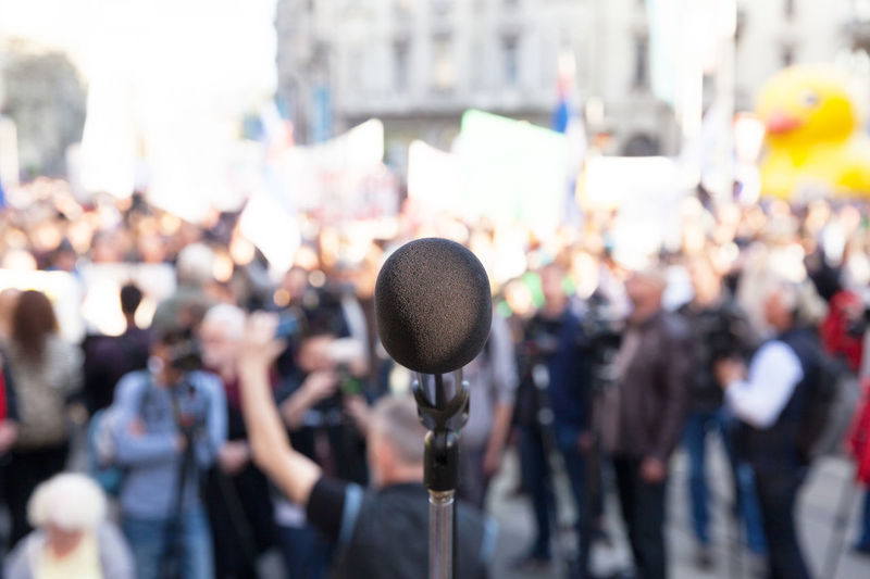 Close-up of microphone with people in background