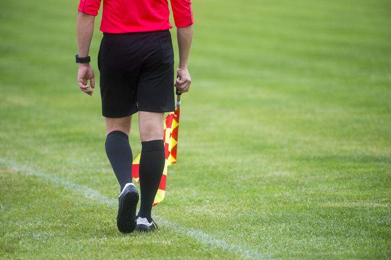 Low section of referee standing on soccer field
