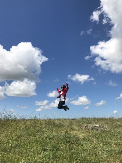 Man jumping on land against sky