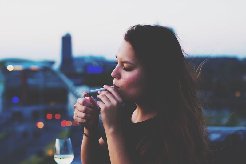 Close-up of woman igniting cigarette