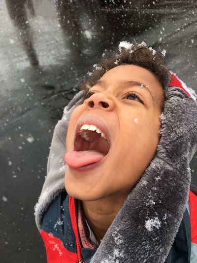 Close-up of boy catching snowflakes