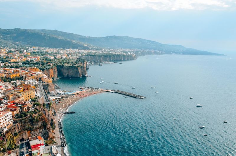 High angle view of townscape by sea against sky