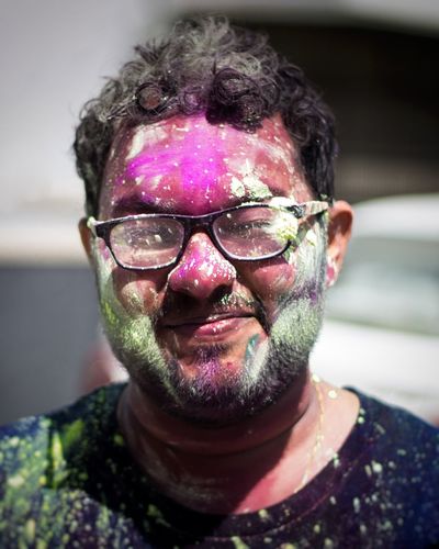 Close-up of smiling man with powder paint on his face during holi