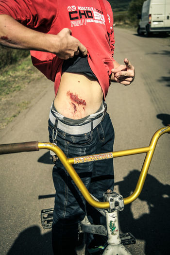 Midsection of cyclist showing wound on street