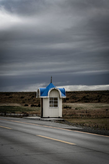 Built structure by road against sky