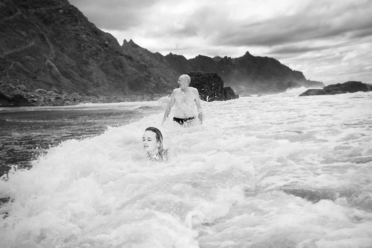 People enjoying in sea against sky
