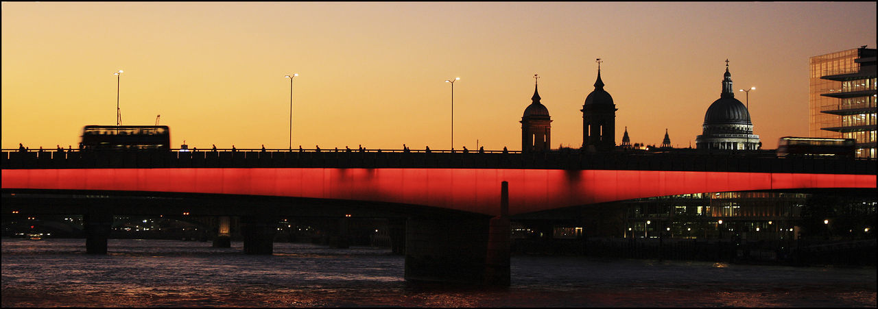 Panoramic view of illuminated london bridge over river against sky at dusk