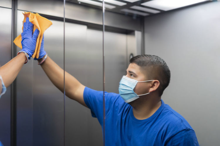 Cleaning professional thoroughly disinfecting the elevator