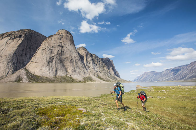 Backpackers hike over arctic tundra in akshayak pass