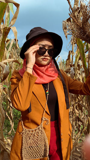Portrait of woman wearing sunglasses while standing against sky