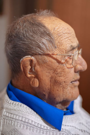 Close-up of senior man looking away while sitting at home