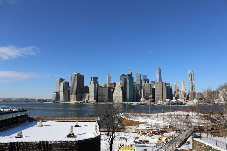 Modern buildings in city against sky during winter