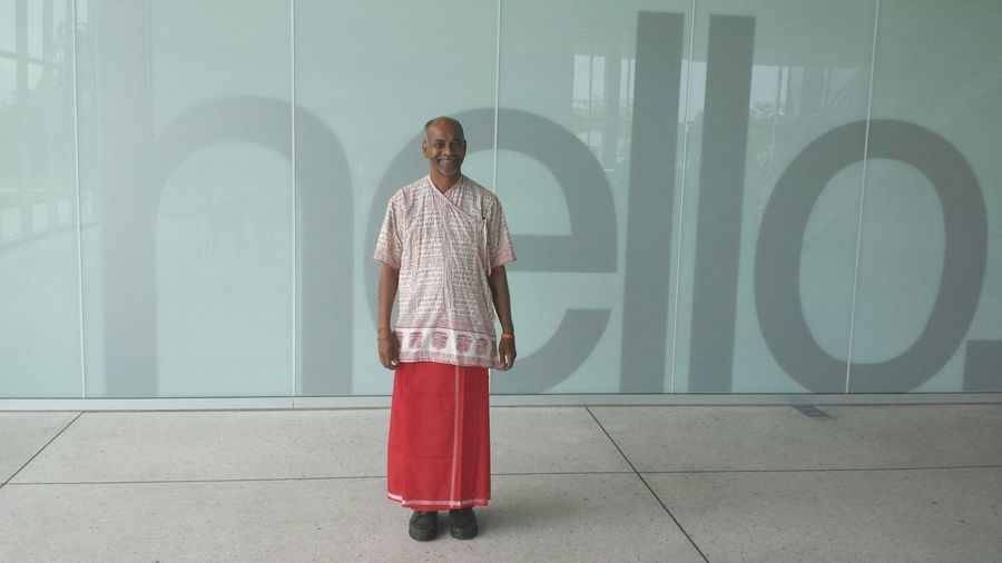 Full length of man wearing traditional clothing standing against wall