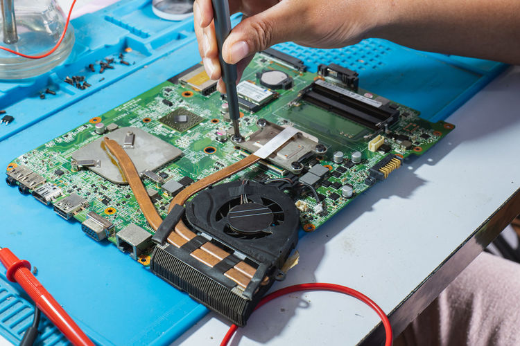 Use a screwdriver to remove the motherboard heat sink for repair.