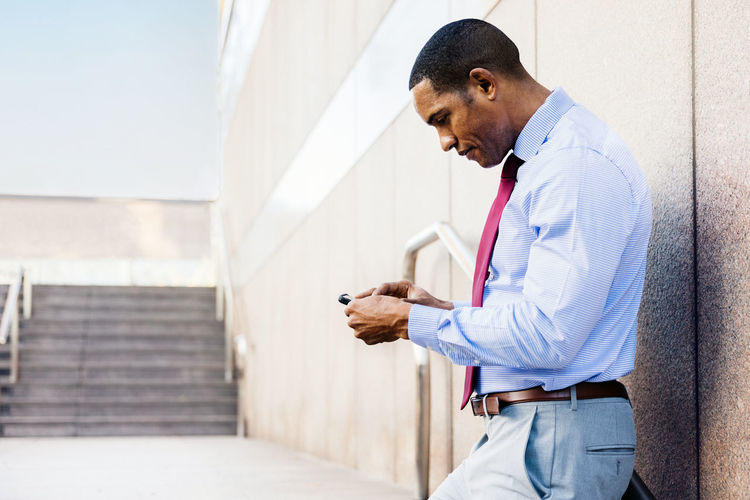 Side view of man standing against wall