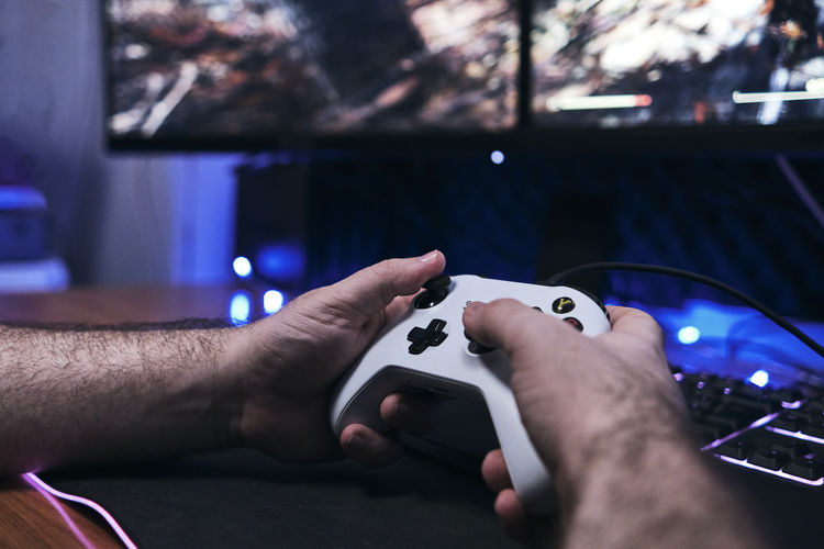 Gamer holding gamepad, controller console in hands. close up.