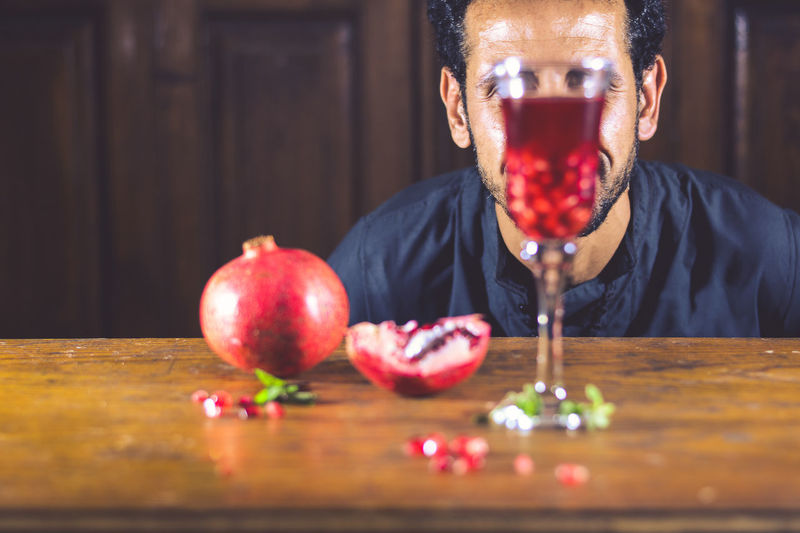 Close-up of man with red wine on table