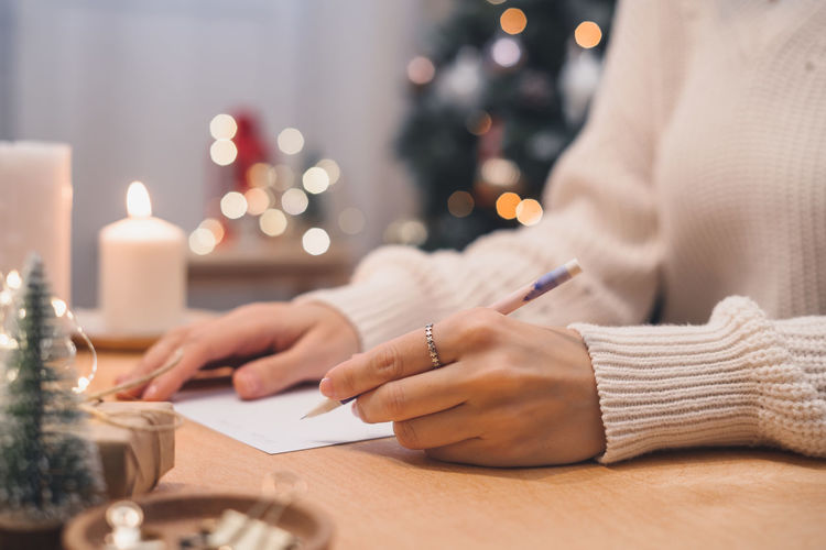 Goals plans to do wish list for new year christmas,  writing in notebook. woman hand with pen and p.