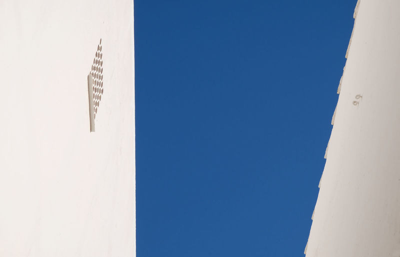 Low angle view of buildings against clear blue sky