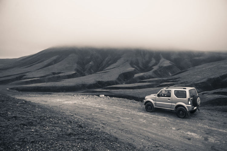 Monochrome of car 4x4 in highlands of iceland, driving on dirt road