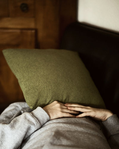 Man face covered with pillow sleeping at home