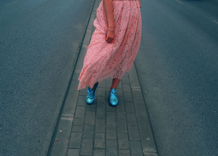 Low section of woman wearing dress while standing on street
