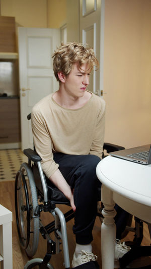 Full length of teenage boy sitting at home