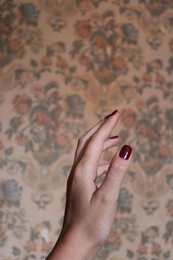 Cropped image of hand holding finger against blurred background