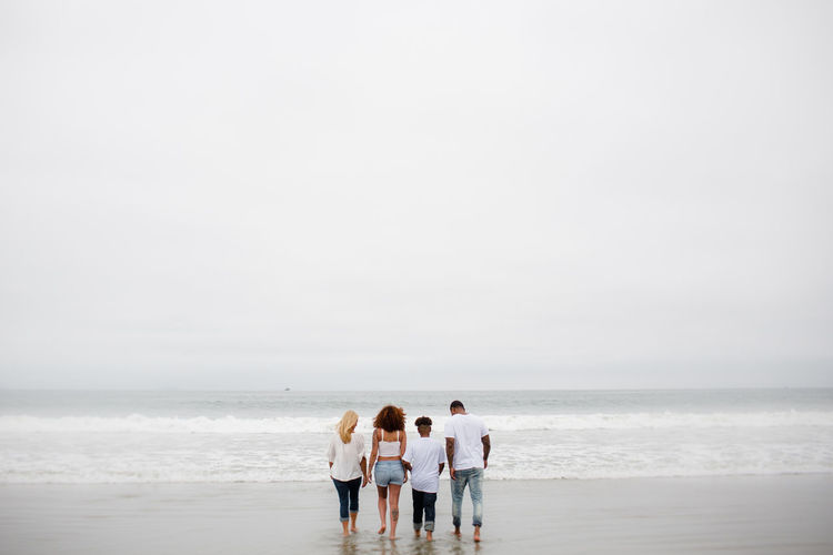 Family walking in water at beach