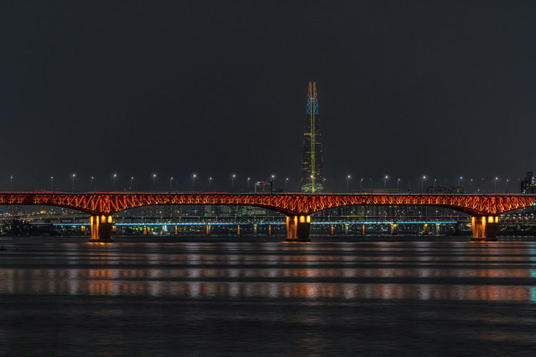 Seongsu bridge and lotte world tower viewed over the han river at night.  seoul, south korea