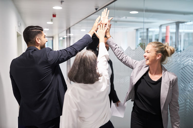Portrait of business colleagues shaking hands in office