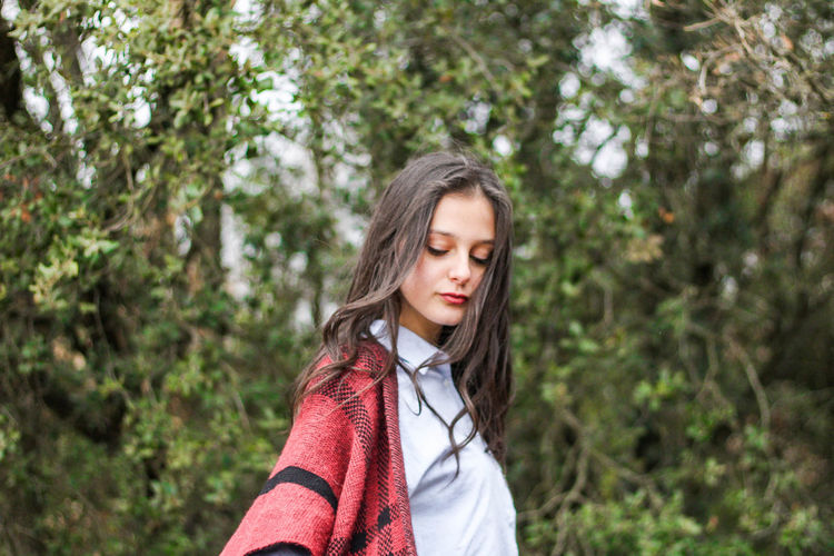 Young girl with poncho in the forest