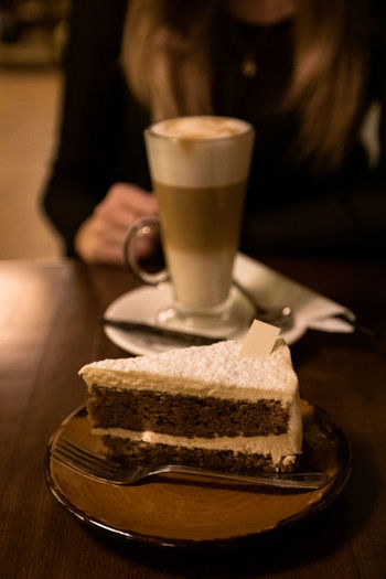 Girl drinking coffee with cheesecake in a cafe