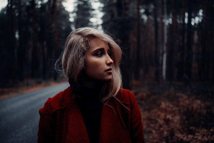 Portrait of young woman looking away in forest