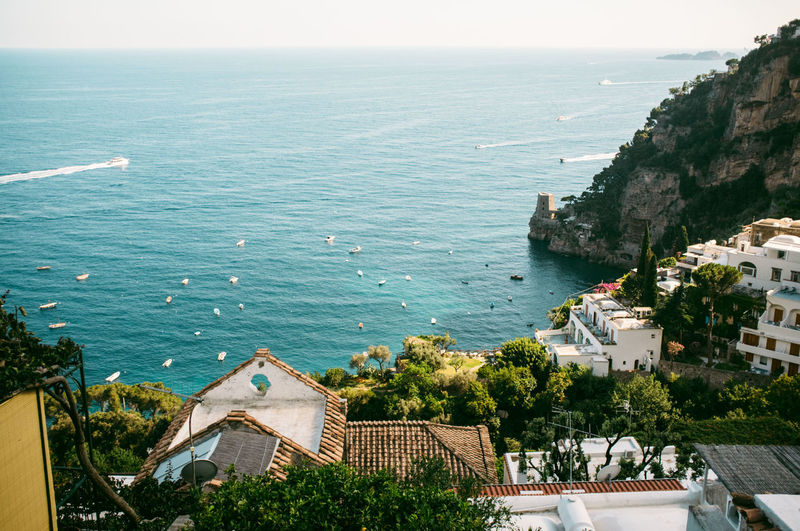 High angle view of buildings and rocky mountains against sea at positano