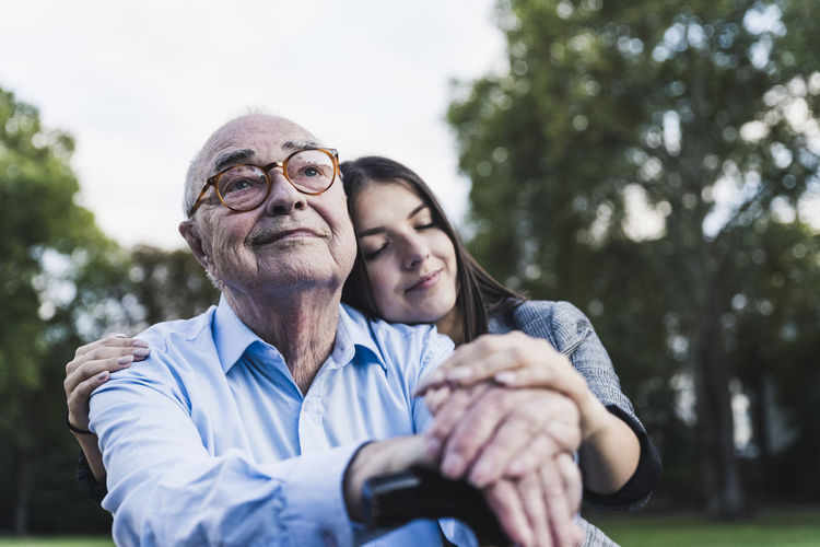 Portrait of senior man with his granddaughter in a park