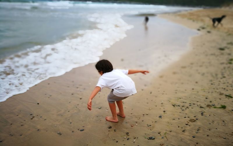 Rear view of boy walking on beach