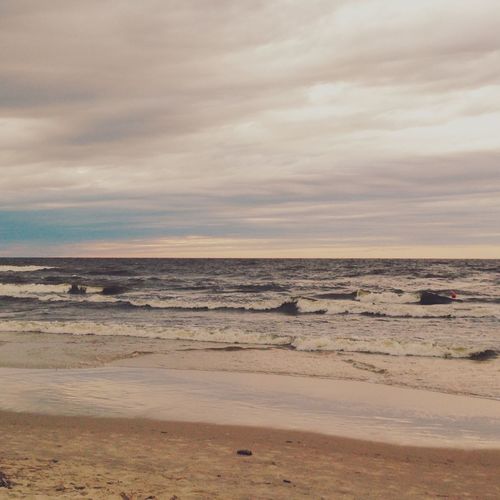 Scenic view of beach against cloudy sky