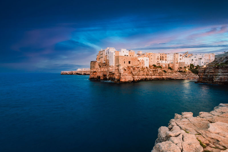 Polignano a mare at sunset, blue hour, seen from the panoramic point in front of the village