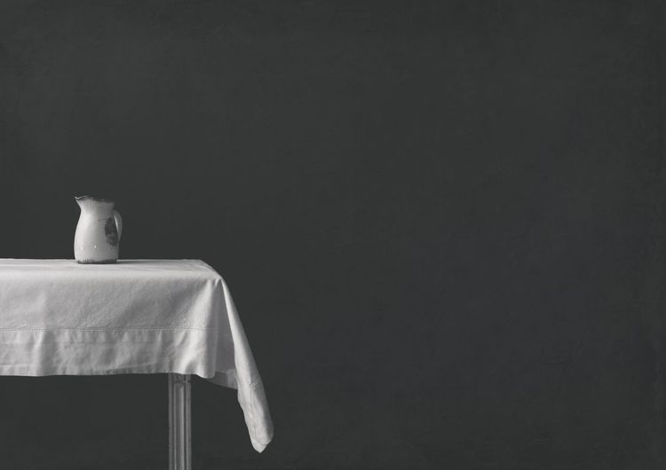 Close-up of container on table against wall